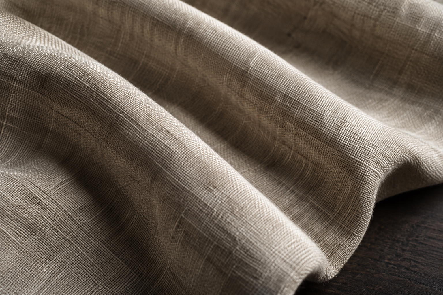 Three broad folds of unbleached linen show bright crests and dark troughs.
