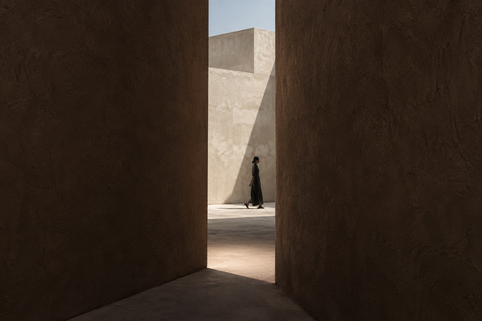 A figure crosses the narrow opening between two large brown walls.